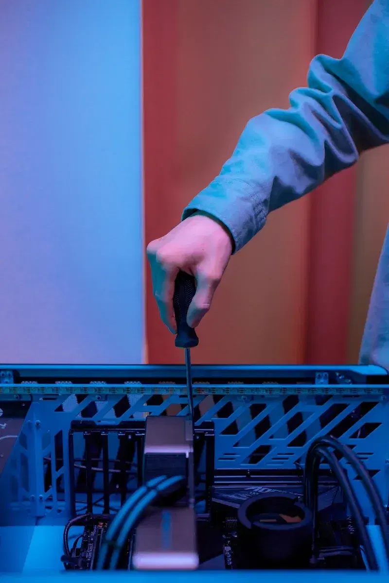 Technician screwing a component into a PC tower